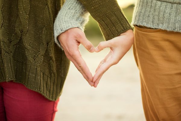 To personer former et hjerte med hendene. Foto.