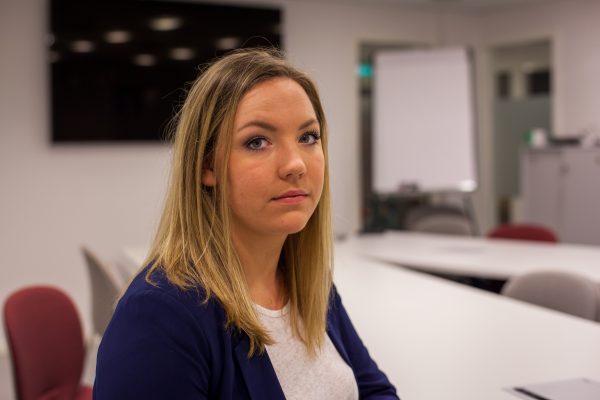Styreleder Camilla Lyngen sitter i et møterom og ser alvorlig i kamera. Foto.
