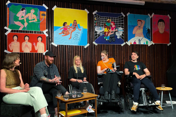 Helserådgiver Nora Thunem sitter med Petter, Henriette, Ingrid og Amir rundt et bord. I bakgrunnen henger seks fargerike illustrasjoner med ulik seksuell tematikk.